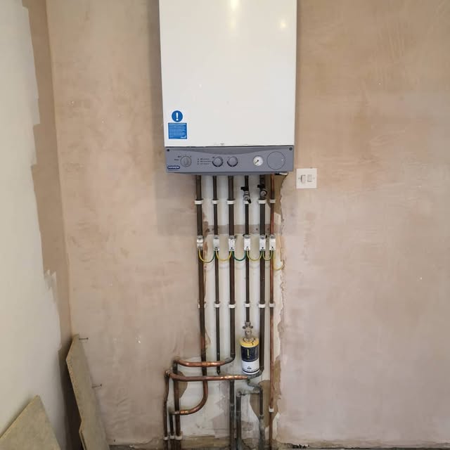 Wall-mounted boiler with neatly arranged pipework